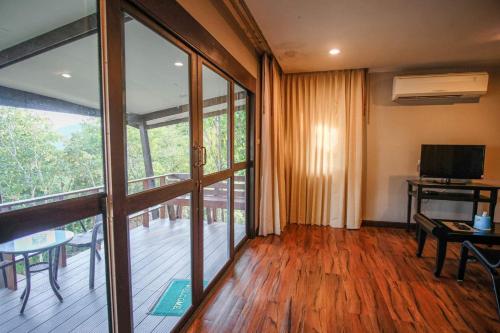 uma sala de estar com portas de vidro deslizantes e uma varanda em Hua Hin Home Hill em Hua Hin