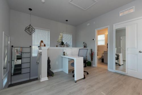 Habitación blanca con escritorio y mesa. en Pet Friendly Modern Zen Studio Retreat with Hot Tub! home en Orlando