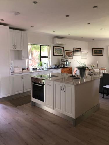 a kitchen with white cabinets and a stove top oven at Waybury Cottage - a cozy home from home ! in Johannesburg
