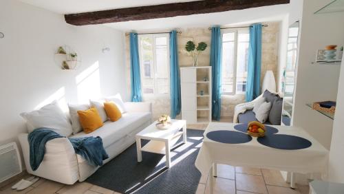 uma sala de estar com um sofá branco e uma mesa em Charmant studio 25 m2 centre ville Avignon em Avignon