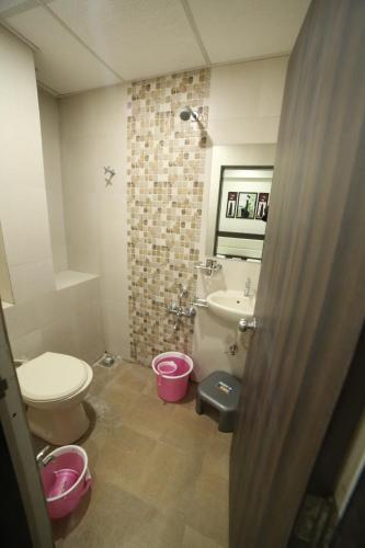 łazienka z toaletą, umywalką i wanną w obiekcie Hotel City Inn w mieście Radźkot