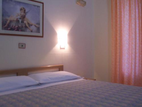 a bedroom with a bed with a light on the wall at Hotel Pensione Romeo in Bari