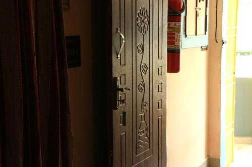 a wooden door with a metal handle in a room at Paradise corner in Pondicherry