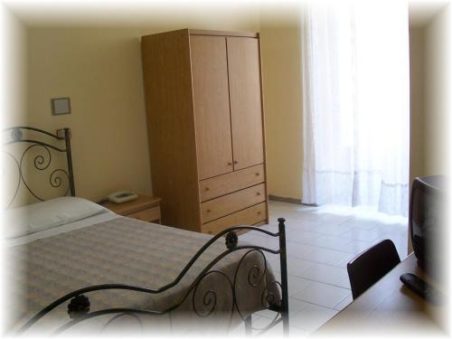 a bedroom with a bed and a dresser and a cabinet at Hotel Pensione Romeo in Bari