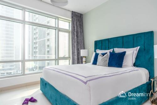 a bedroom with a large bed and a large window at Dream Inn Apartments - Loft Towers in Dubai
