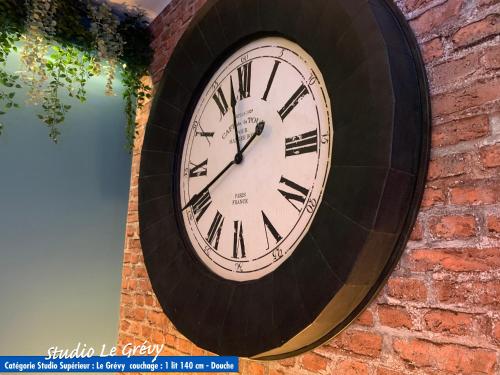 a clock on the side of a brick wall at Nos studios au centre ville à Dole in Dole