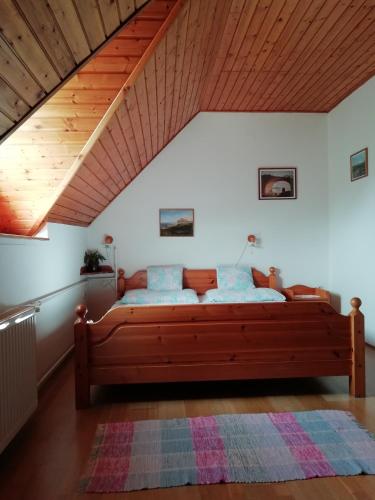 um quarto com uma grande cama de madeira num sótão em Villa Mediterrán em Zalakaros