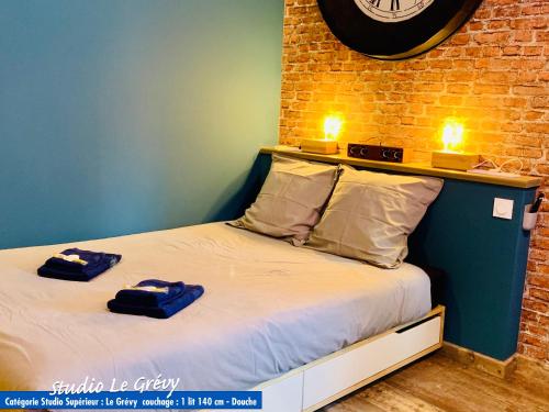 a bedroom with a bed with two towels on it at Nos studios au centre ville à Dole in Dole
