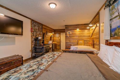 Vacationland Inn & Suites في Brewer: غرفة نوم بسرير وتلفزيون في غرفة