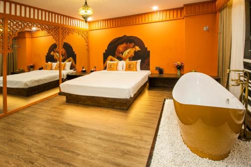 a bedroom with two beds and a bath tub at EROS HOTEL 2 - Love Hotel in Ho Chi Minh City
