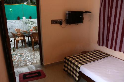 a small room with a bed and a table with a dining room at Paradise corner in Pondicherry