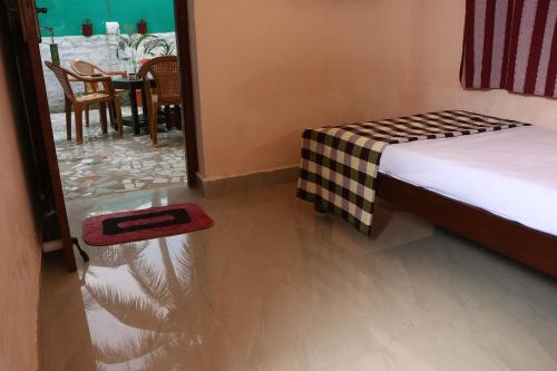 a bedroom with a bed and a table and chairs at Paradise corner in Pondicherry