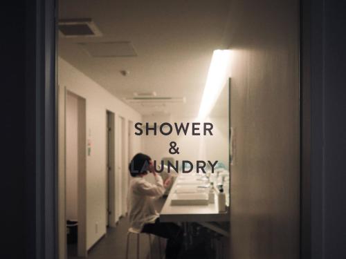 a woman looking at herself in a bathroom mirror at UNPLAN Kagurazaka in Tokyo