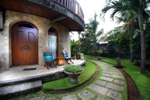 
a garden area with a patio and a bench at Dewani Villa Resort in Canggu
