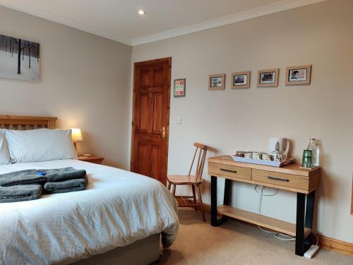 um quarto com uma cama e uma secretária de madeira em Nant Gloyw Oswestry em Oswestry