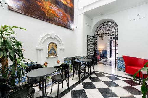a restaurant with tables and chairs and a painting on the wall at Cool Sevilla Hotel in Seville