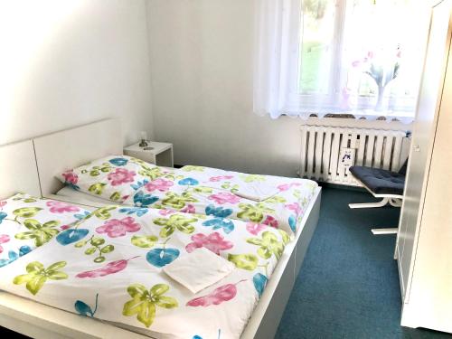 a bedroom with a bed with a floral bedspread at Apartament Familia in Ustrzyki Dolne