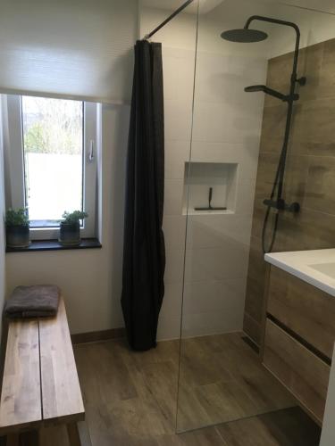 a bathroom with a shower with a glass door at Auberge Sans Souci in Valkenburg