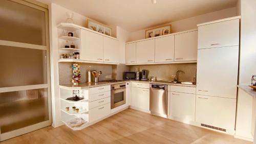 a white kitchen with white cabinets and a refrigerator at "Lodge Domblick" in Limburg an der Lahn