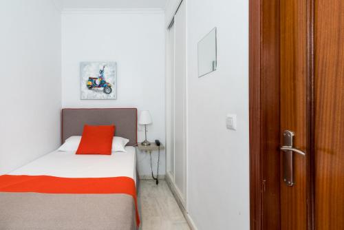 a bedroom with a bed with a red pillow on it at Cool Sevilla Hotel in Seville
