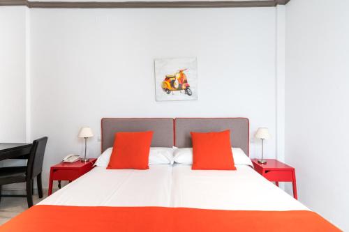a bedroom with a large bed with two red tables at Cool Sevilla Hotel in Seville