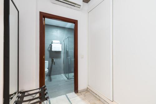 a bathroom with a walk in shower and a toilet at Cool Sevilla Hotel in Seville