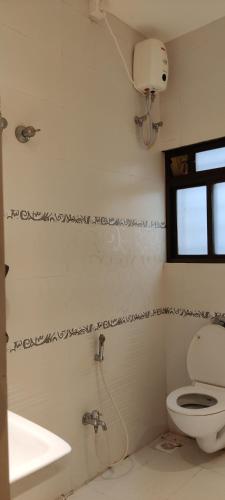 a bathroom with a toilet and a sink and a window at Rankala Lakeview in Kolhapur