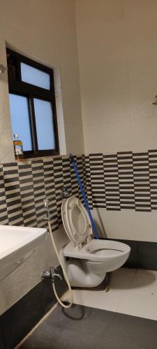 a bathroom with a toilet and a sink at Rankala Lakeview in Kolhapur
