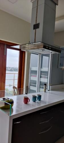 a kitchen with three cups sitting on a counter at Rankala Lakeview in Kolhapur