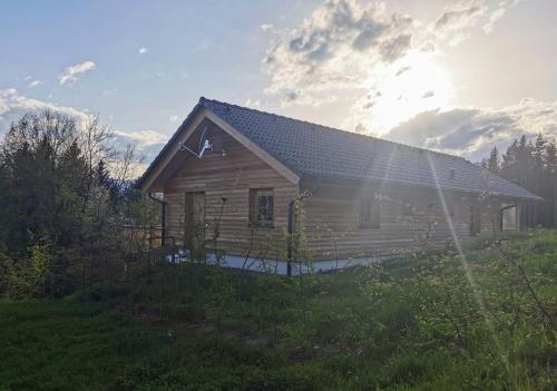 une cabane en rondins où le soleil brille derrière elle dans l'établissement Das Koralpenchalet...Sonne, Wald, Natur!, à Trahütten