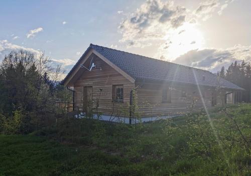 a log cabin with the sun shining behind it at Das Koralpenchalet...Sonne, Wald, Natur! in Trahütten