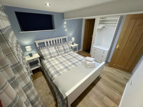 a bedroom with a bed and a tv on the wall at Lovely ground floor apartment in quiet village in Exeter