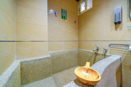 a bathroom with a wooden bowl in the middle of a tub at 鼎愛溫泉行館 in Jiaoxi