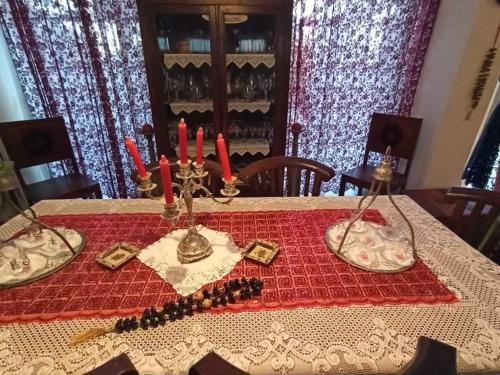 a table with a red table cloth with candles on it at Anatoli Hotel in Agia Marina Aegina