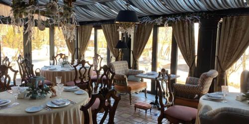 un comedor con mesas, sillas y ventanas en Boutique Hotel Seneshal en Solnechnogorsk