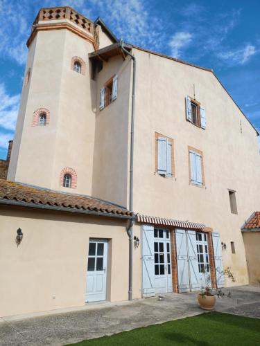 a large white building with a tower at La tour Laffage in Cintegabelle