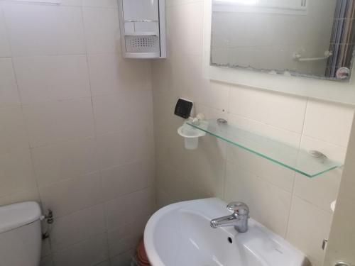 a bathroom with a sink and a toilet and a mirror at résidence les jardins in El Aouina