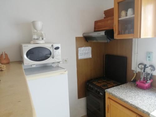 a kitchen with a microwave on top of a refrigerator at résidence les jardins in El Aouina