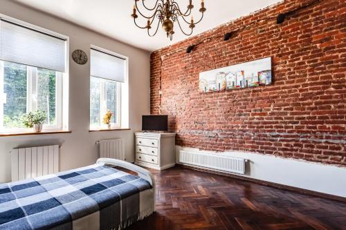 a bedroom with a brick wall and a bed at Green Garden !svitlo postiyno! in Lviv