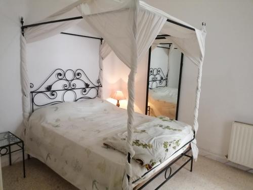 a bedroom with a white bed with a canopy at résidence les jardins in El Aouina