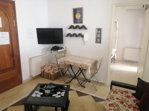 a living room with a tv and a table at résidence les jardins in El Aouina