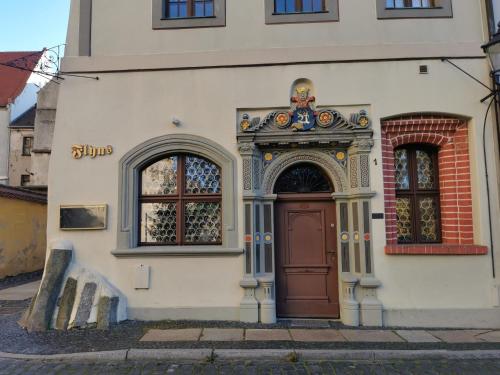 um edifício com uma porta castanha e duas janelas em Flyns em Görlitz