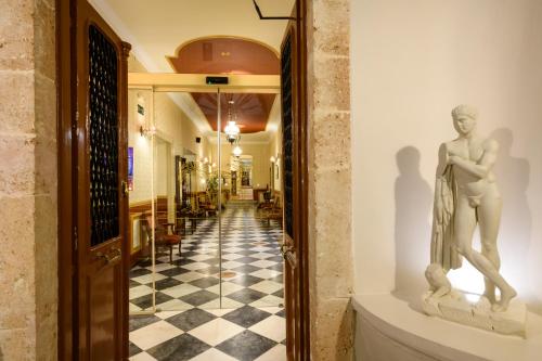 a statue of a man on a wall in a hallway at Halepa Hotel in Chania