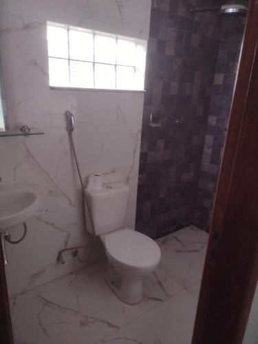 a bathroom with a toilet and a sink at Casa do Francês na Praia in Boa Vista