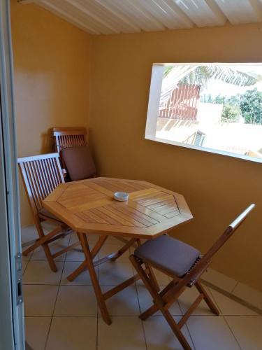 a table and chairs in a room with a window at Terre et Mer - Studios - Ile Maurice in Rivière Noire