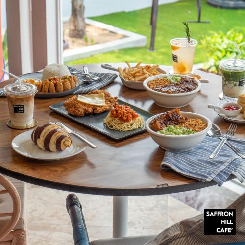 a table with plates of food and drinks on it at Saffron Hill Minburi in Min Buri