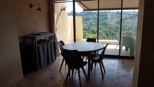 a table and chairs in a kitchen with a view at Callian: lumineux duplex avec terrasse et vue in Callian
