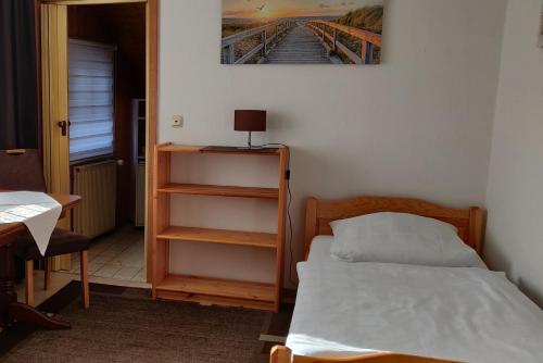 a small bedroom with a bed and a book shelf at Pension Burger - Bed & Breakfast in Weibersbrunn