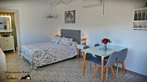 a bedroom with a bed and a table and chairs at Alojamiento Rural Tetuán in Árchez