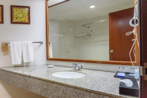 La salle de bains est pourvue d'un lavabo et d'un miroir. dans l'établissement J Beach Suites At Rainbow Paradise, à Tanjung Bungah